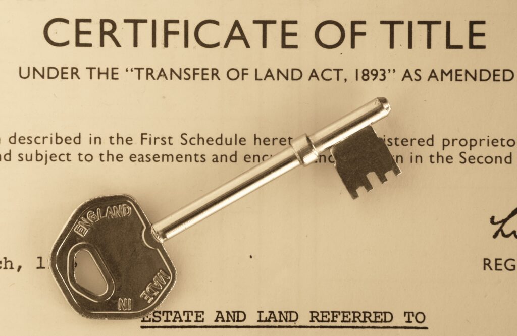Certificado de título de propiedad con llaves, simbolizando la formalización exitosa de un predio en Colombia